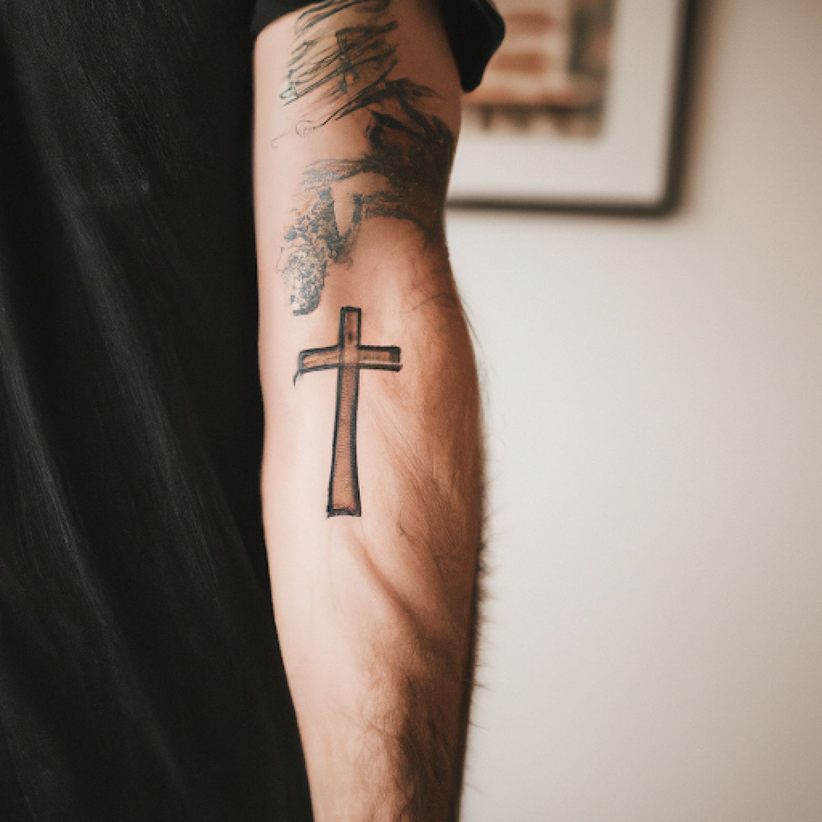 Cross tattoo on arm for men