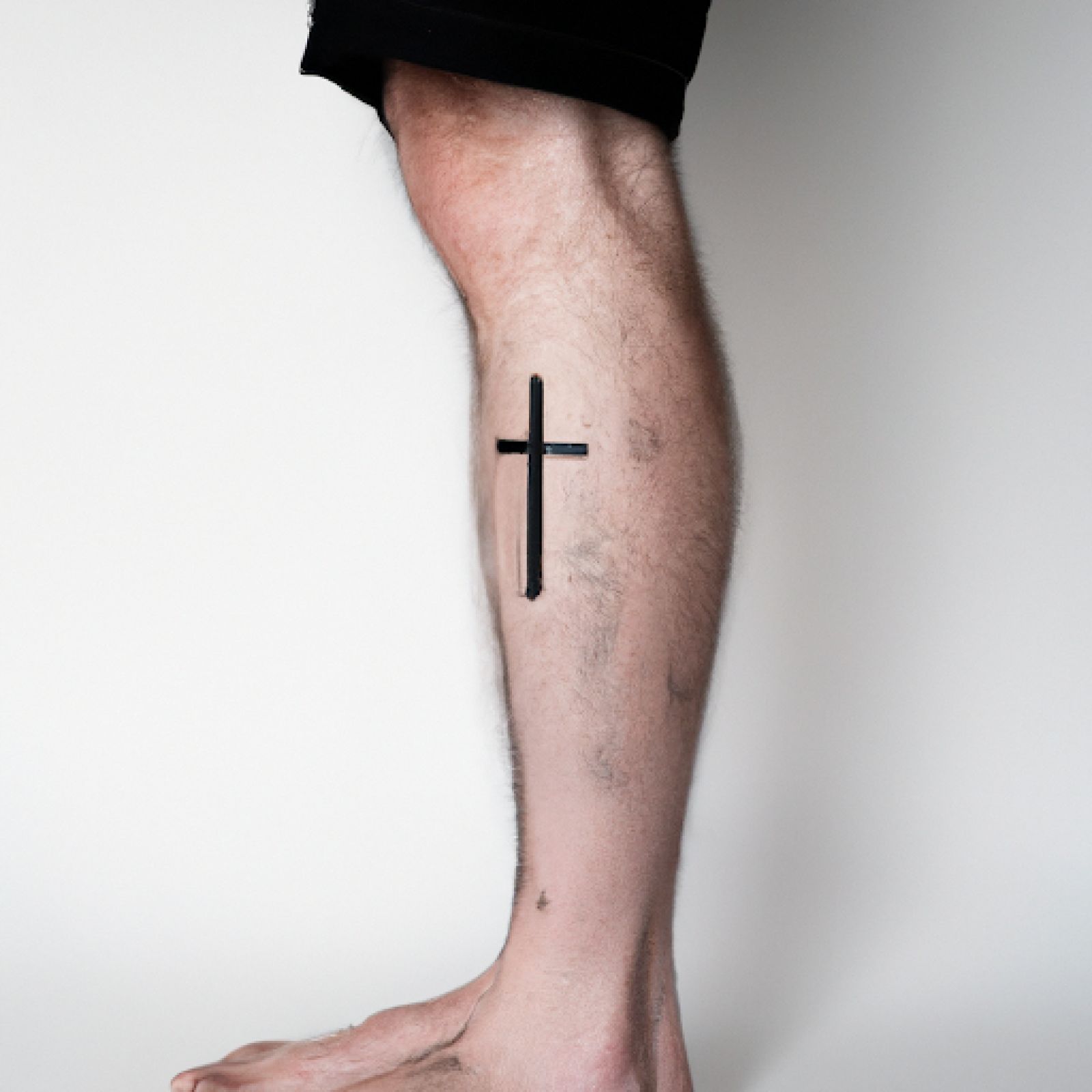Cross tattoo on leg for men