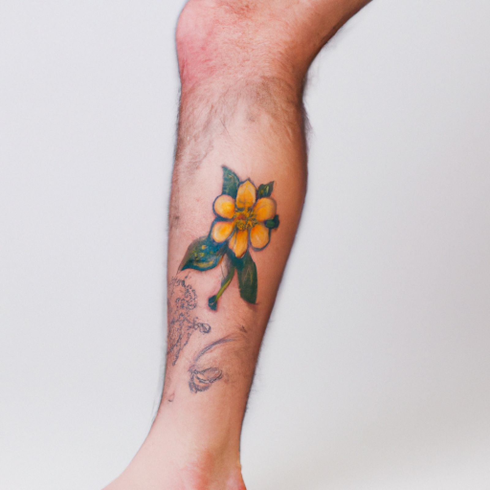 Flower tattoo on leg for men