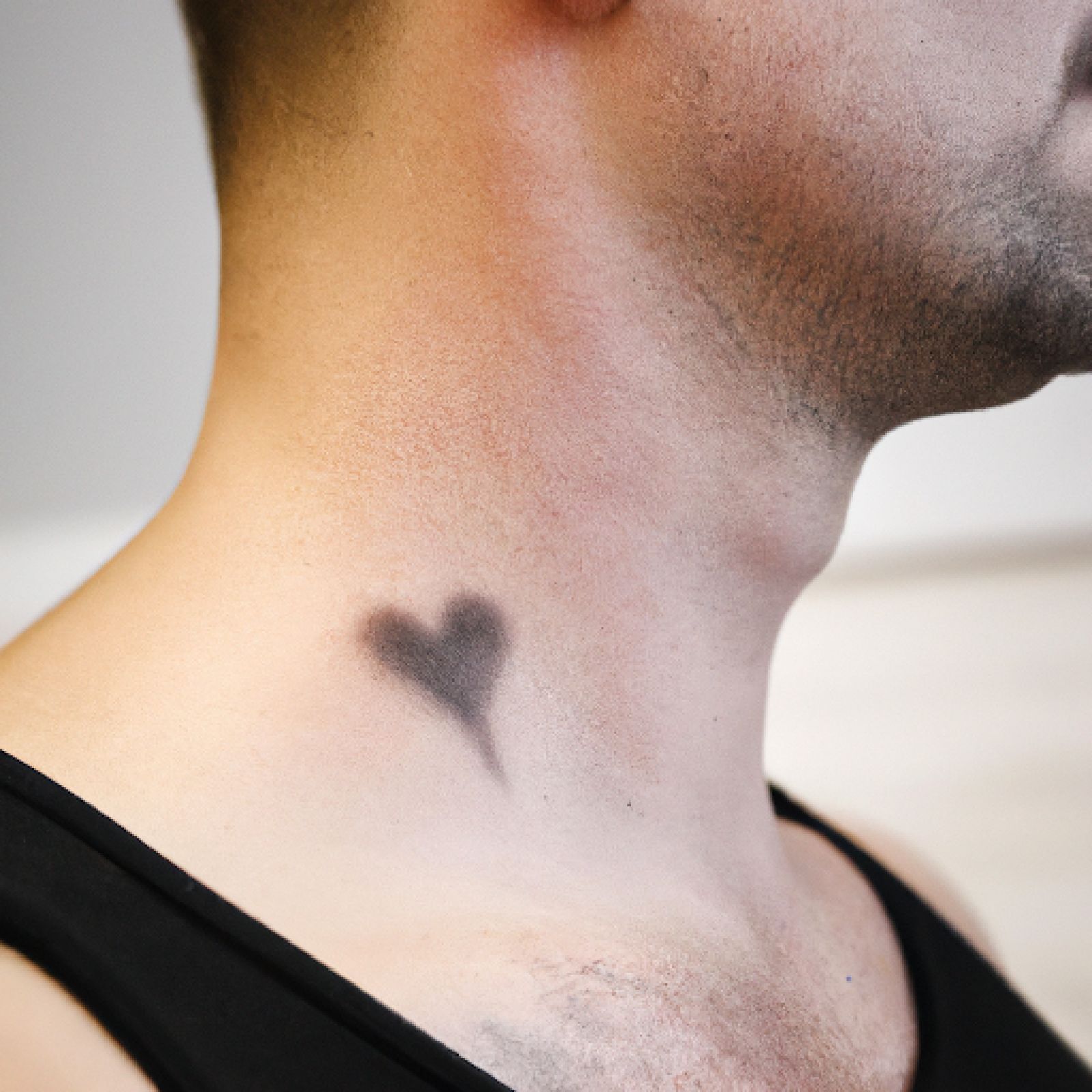 Heart tattoo on neck for men