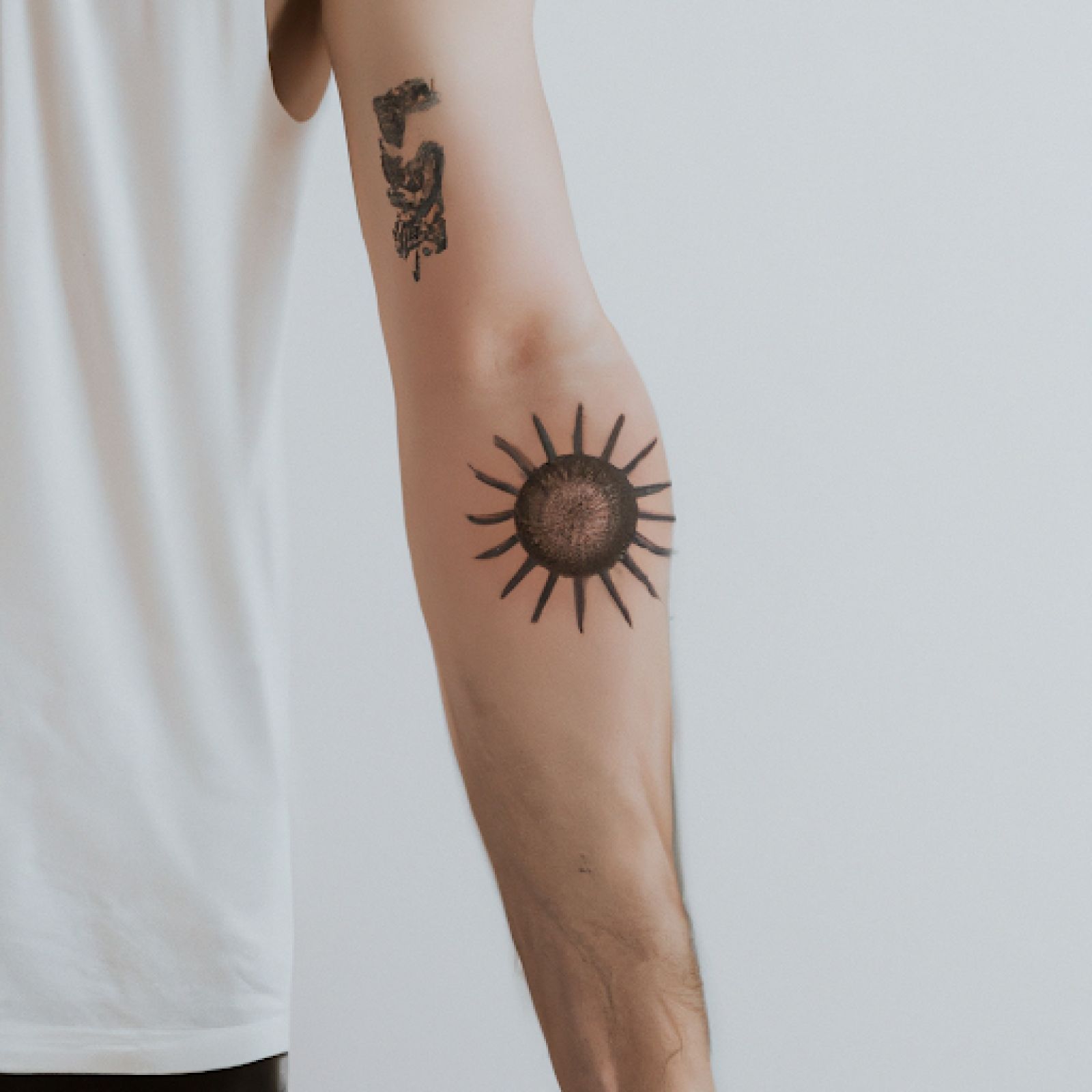 Sun tattoo on arm for men