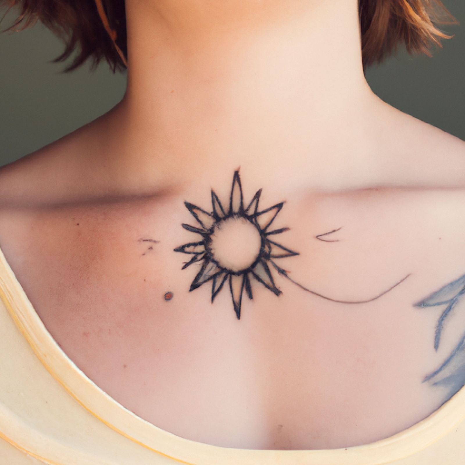 Sun tattoo on neck for women