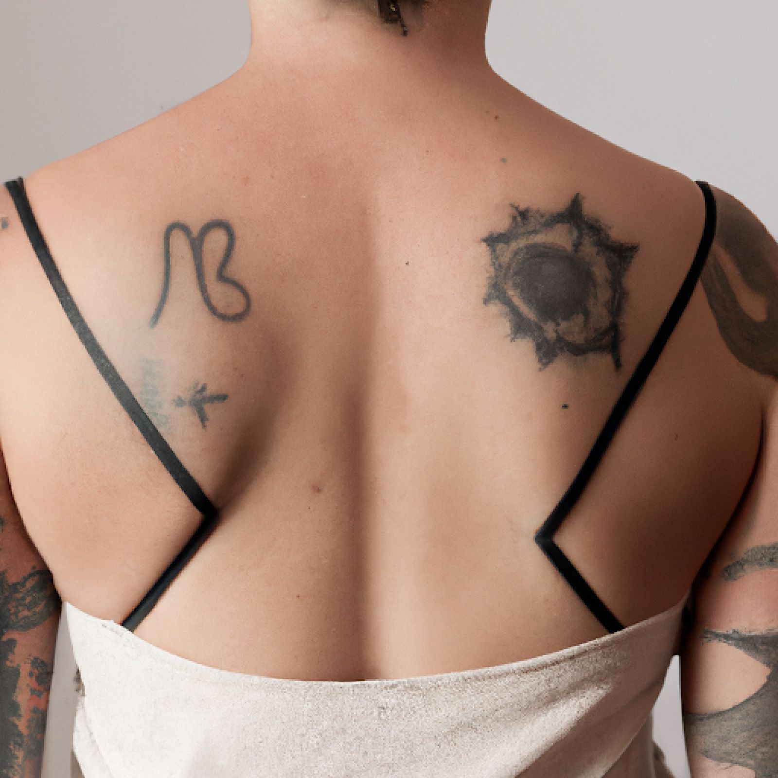 Trash polka tattoo on back for women