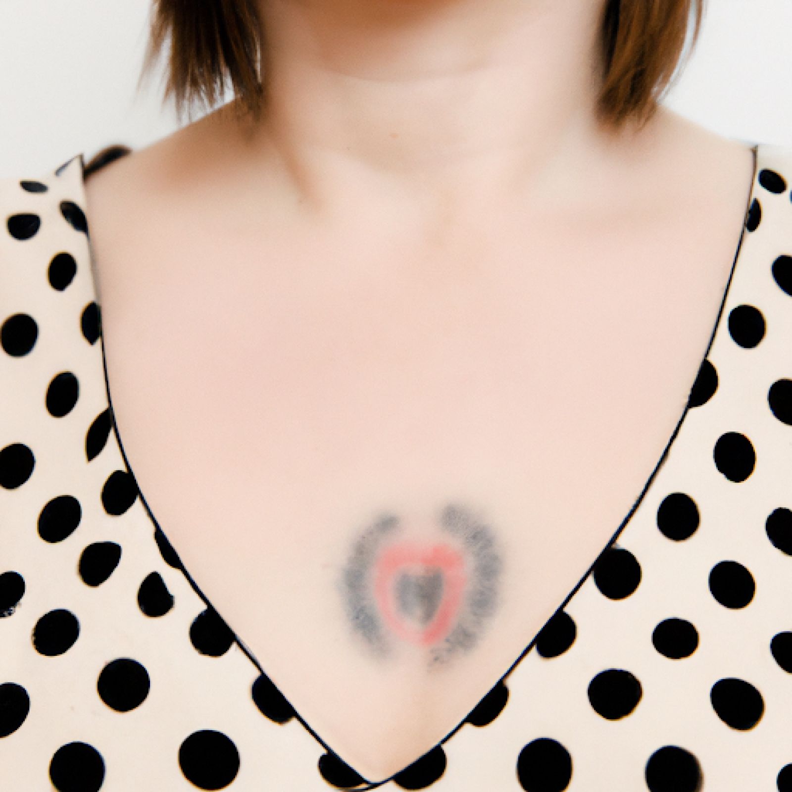 Trash polka tattoo on sternum for women