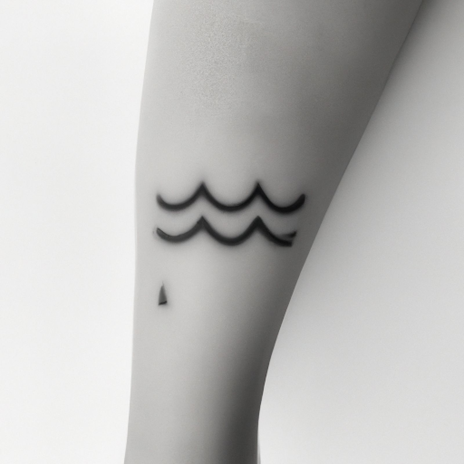 Wave tattoo on calf for women