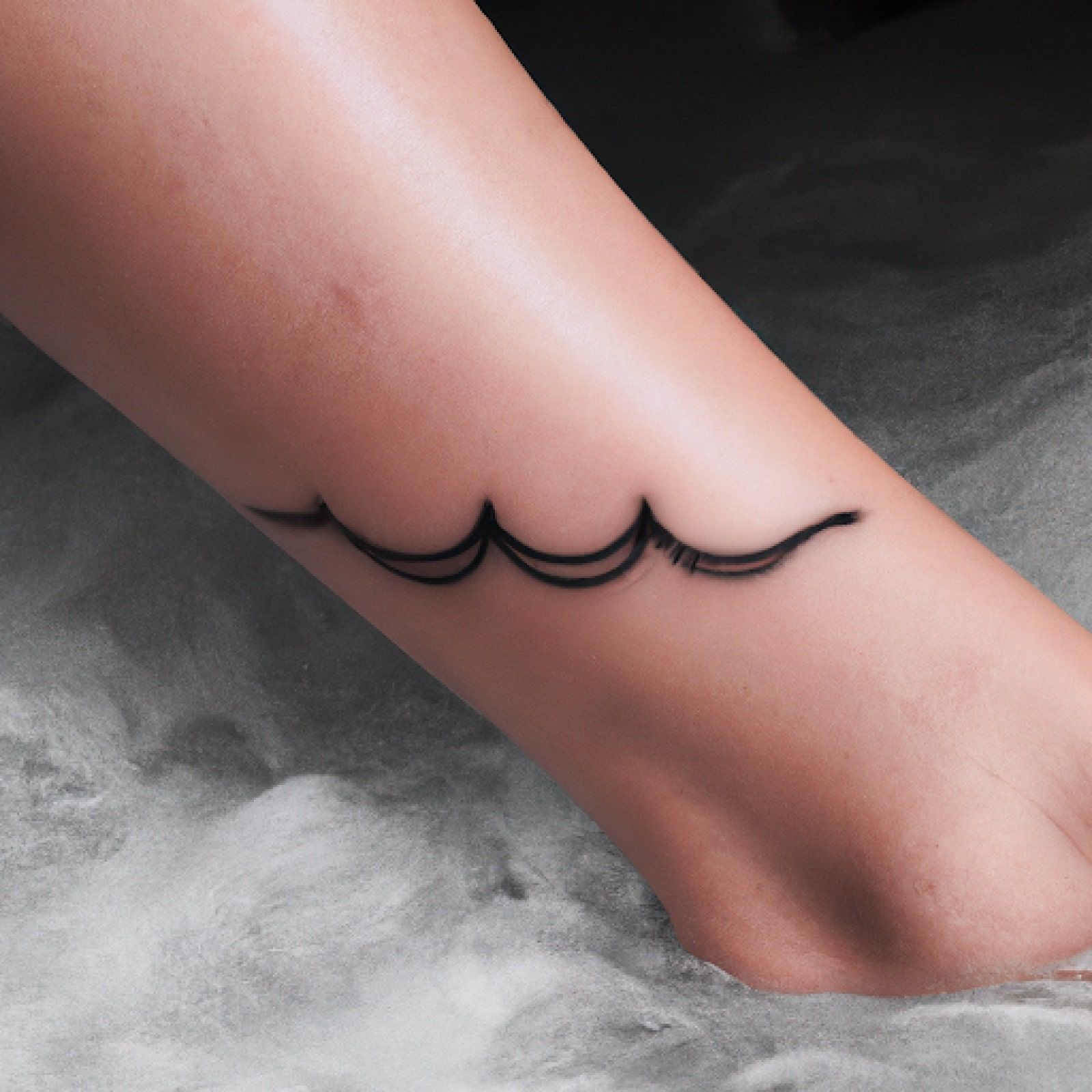 Wave tattoo on leg for women