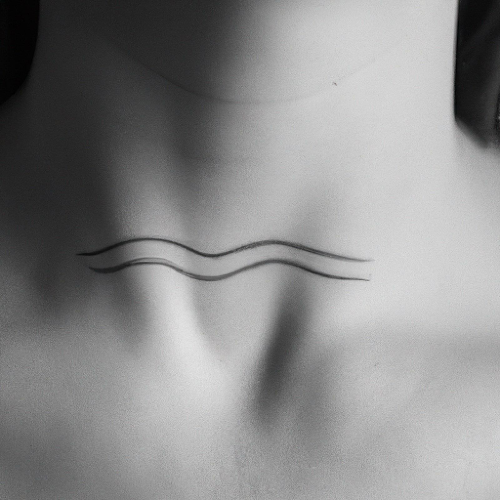 Wave tattoo on neck for women