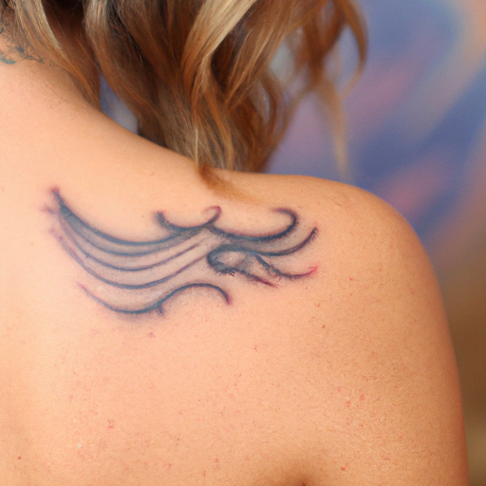 Wave tattoo on shoulder for women