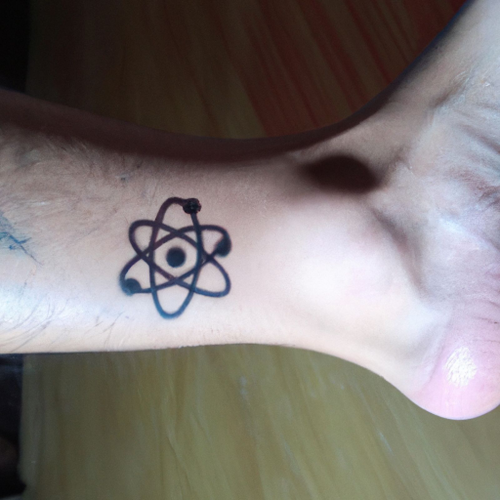 Atom tattoo on ankle for men
