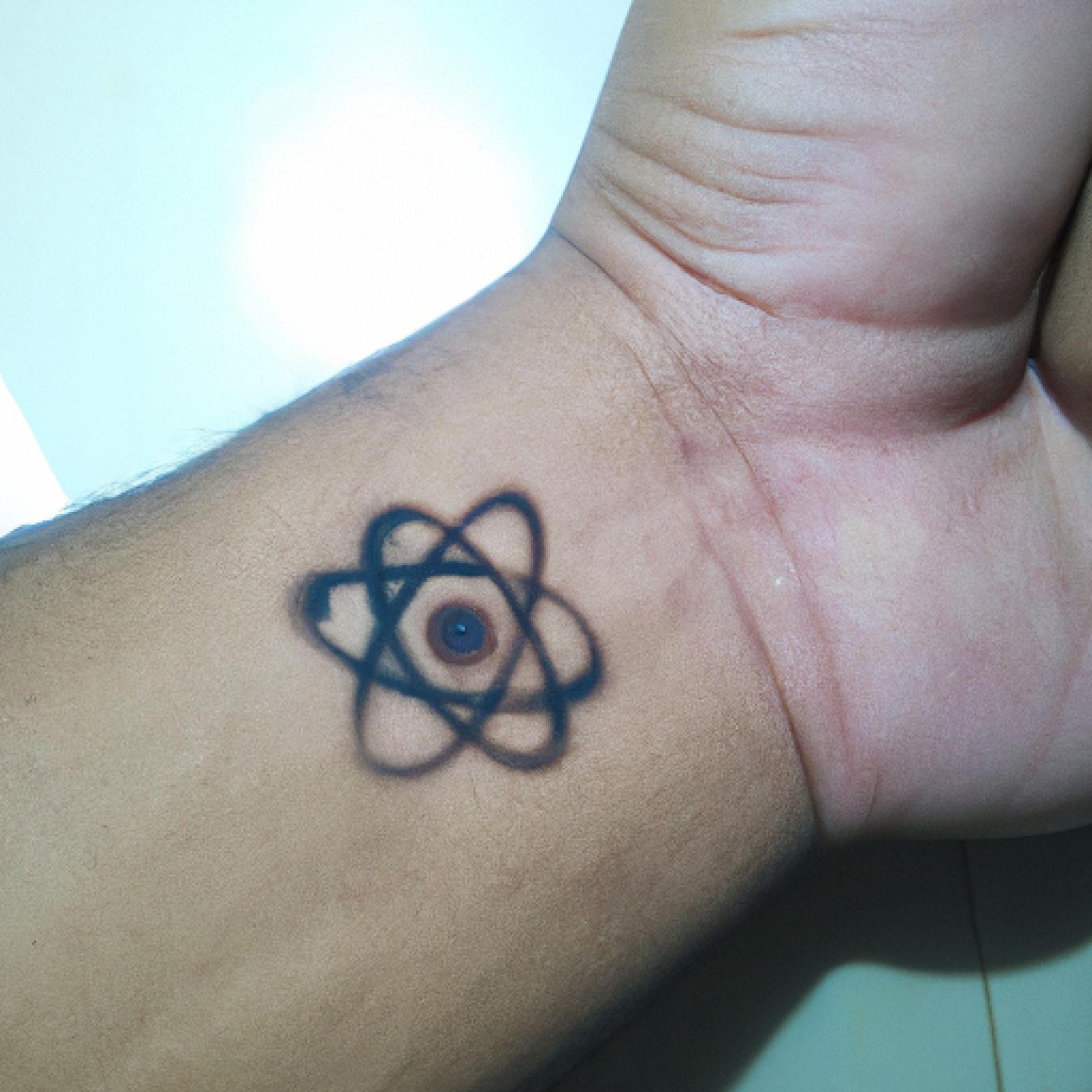 Atom tattoo on hand for men