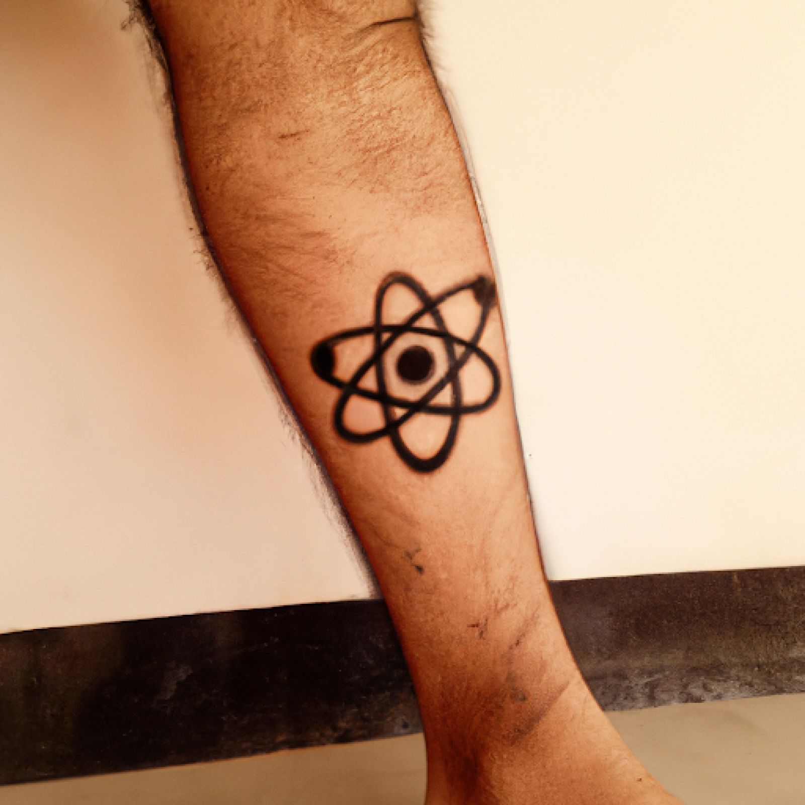 Atom tattoo on leg for men