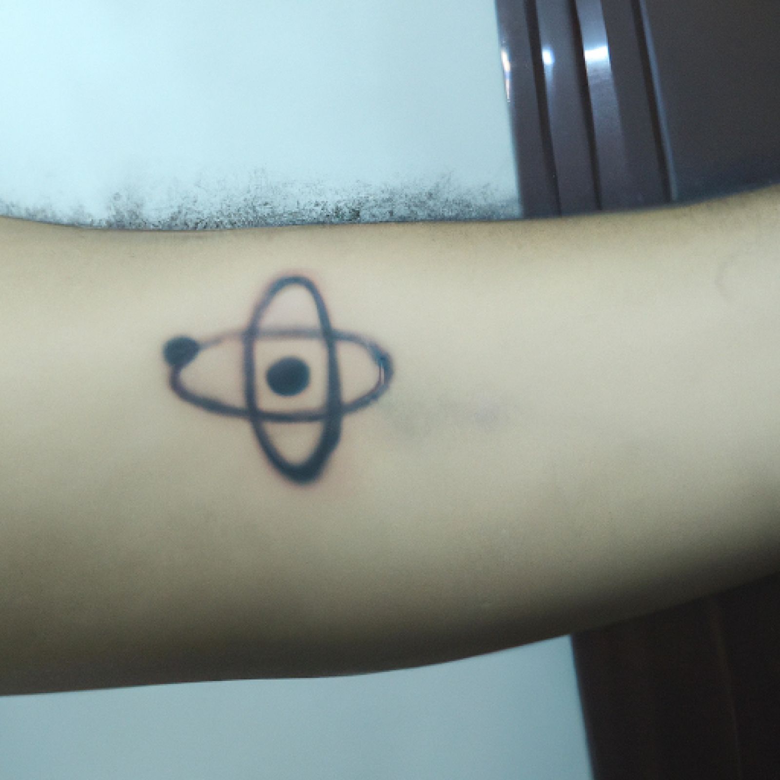 Atom tattoo on side for men