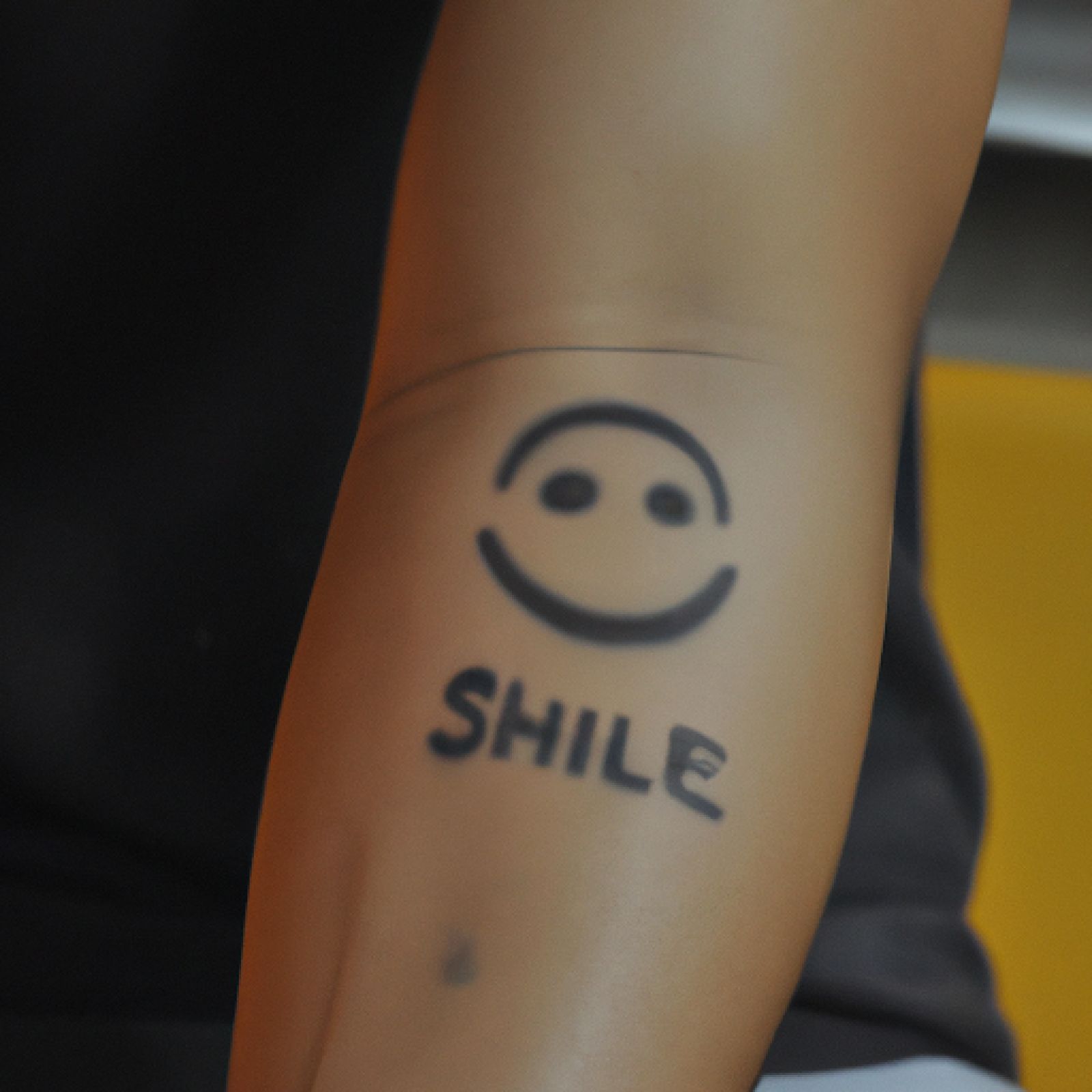 Smiley tattoo on forearm for men