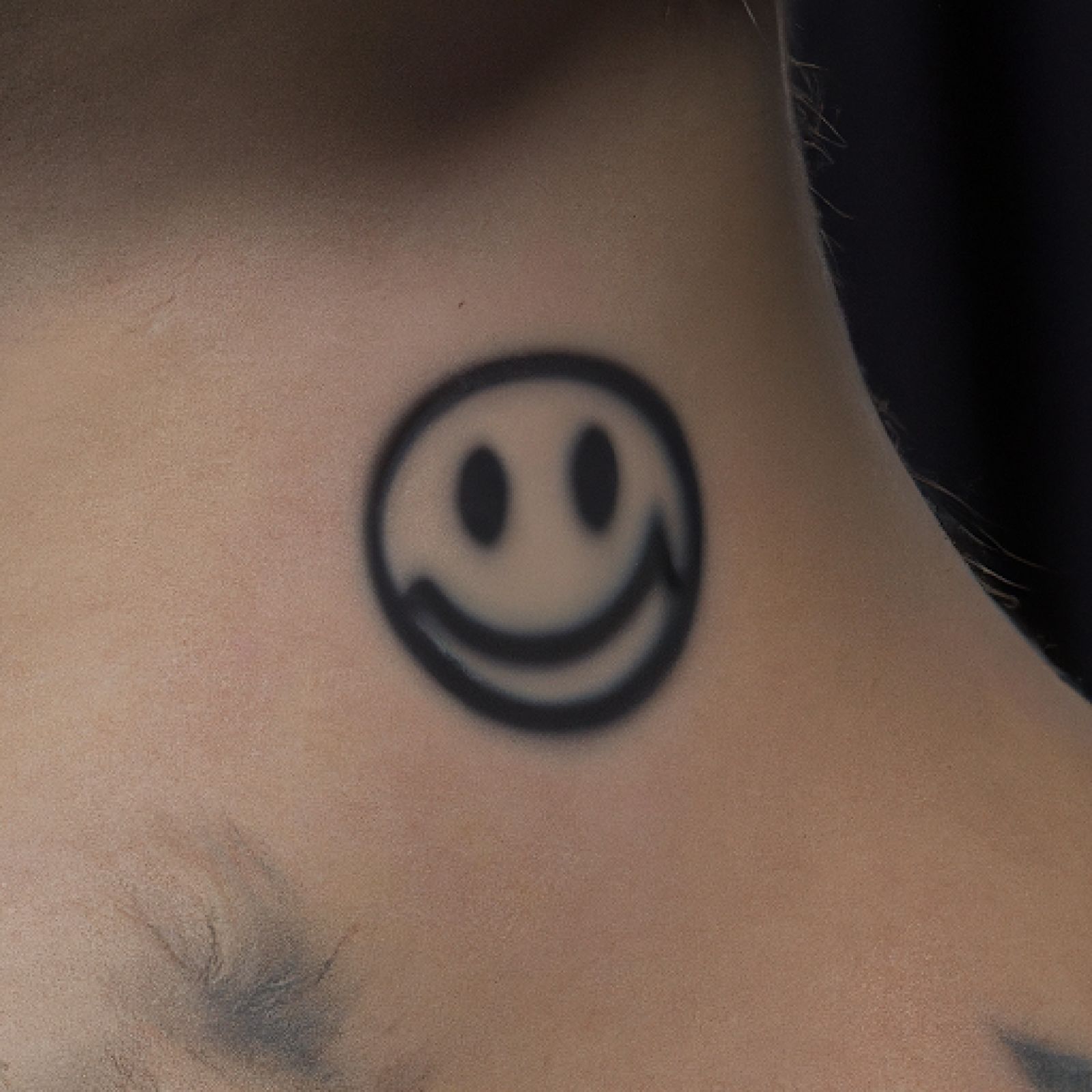Smiley tattoo on shoulder for men