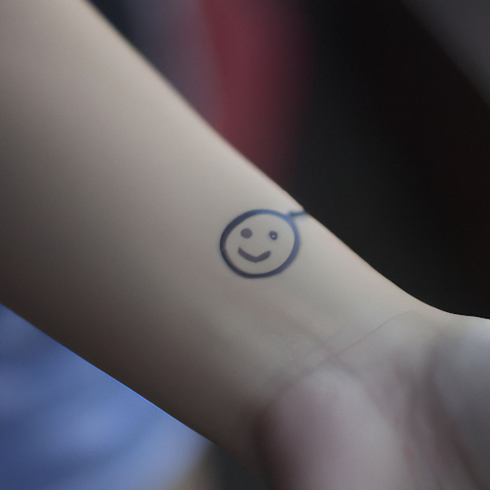 Smiley tattoo on wrist for women