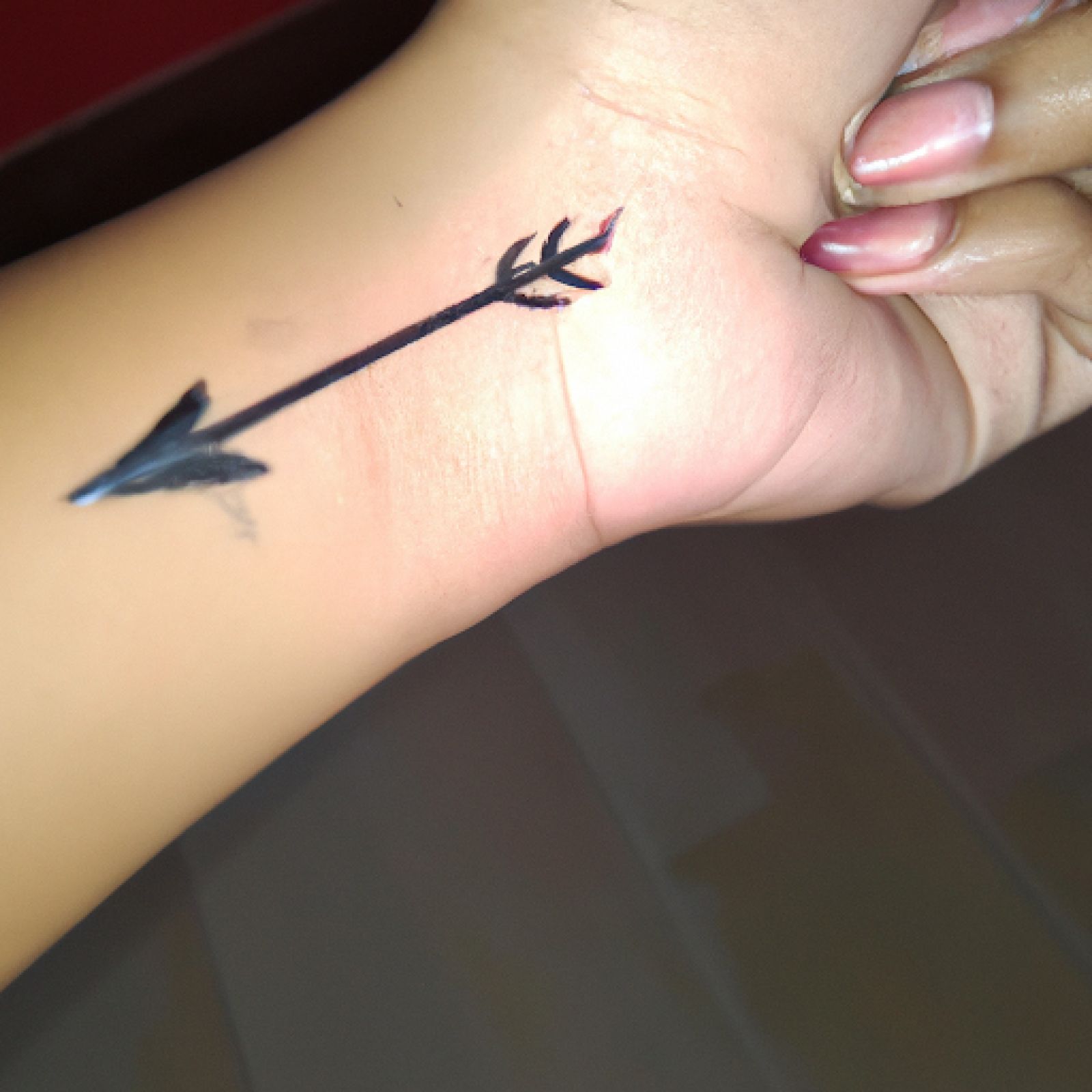Arrow tattoo on hand for women