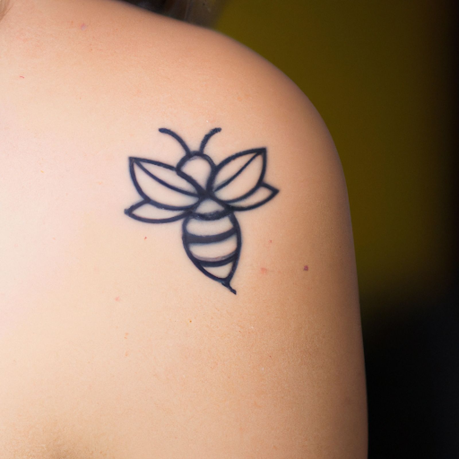 Bee tattoo on back for women