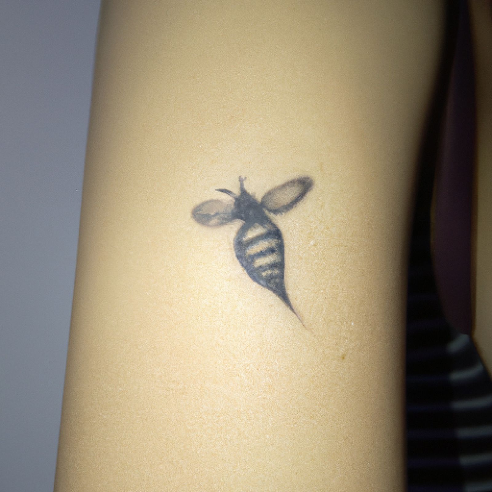 Bee tattoo on side for women